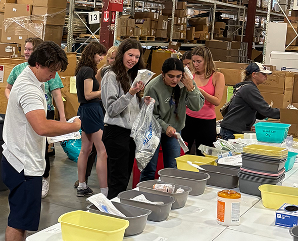 students sorting items in a warehouse during a Day of Service project