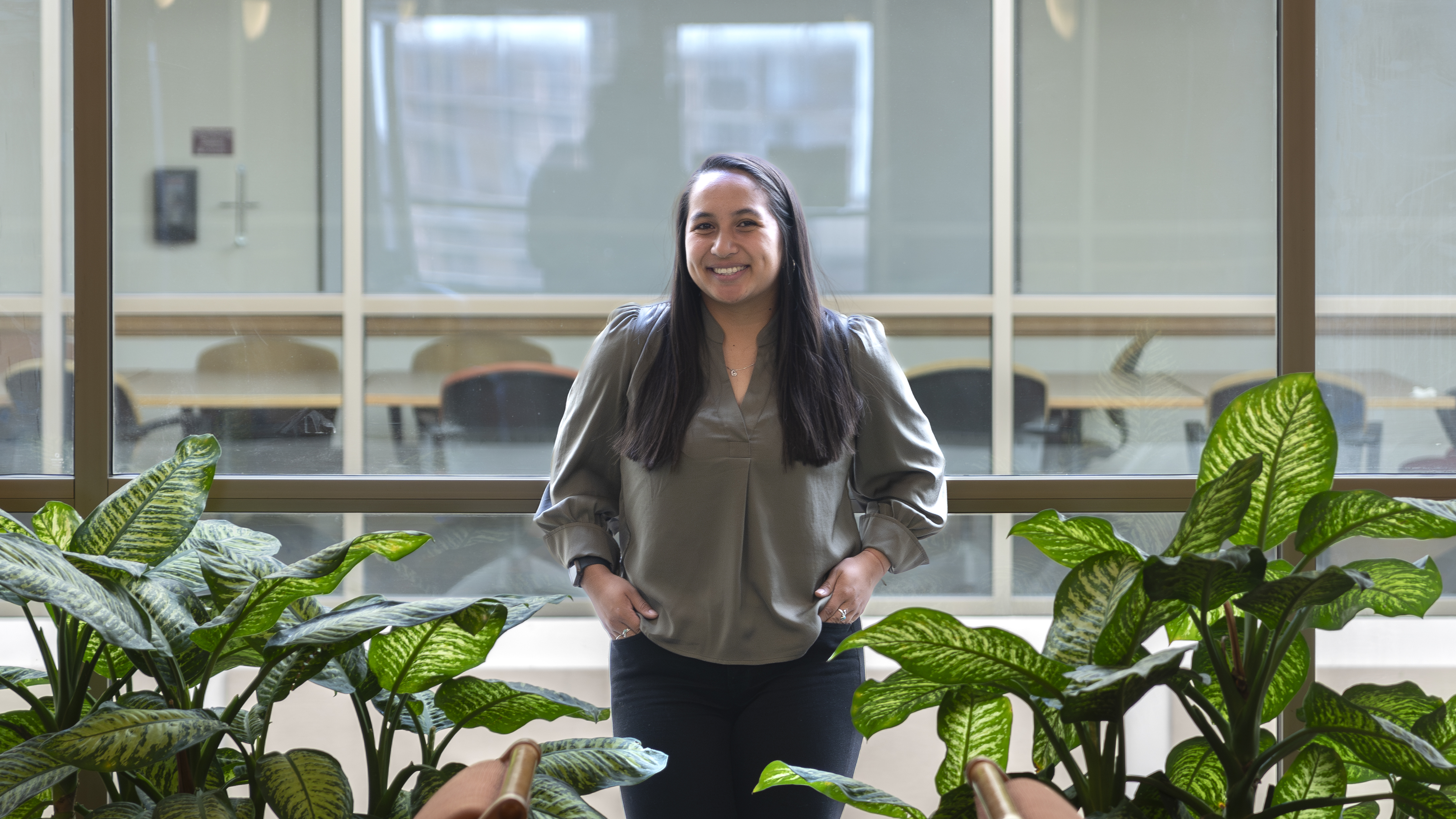 DU Sturm Law student Caley Carlson poses for a photo among greenery in the Sturm College of Law.