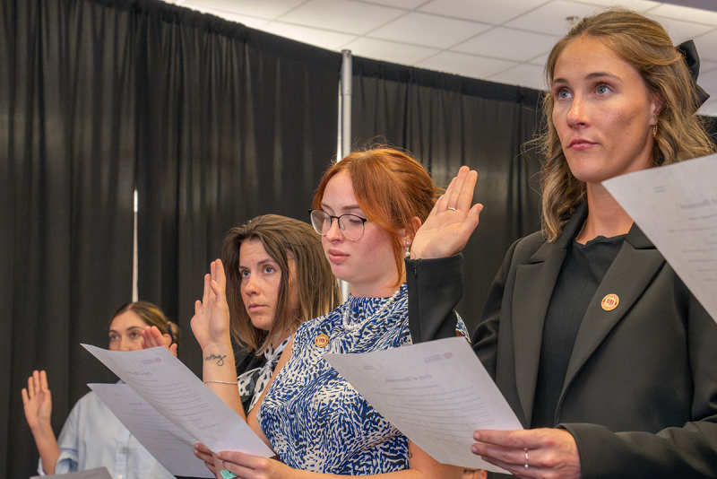 Student Attorneys with hands raised in swearing-in ceremony